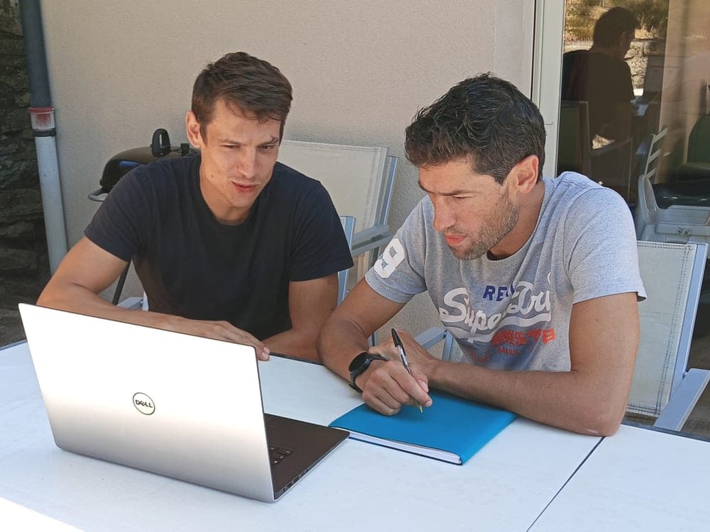 Simon accompagne un client qui prend des notes pendant une séance à domicile